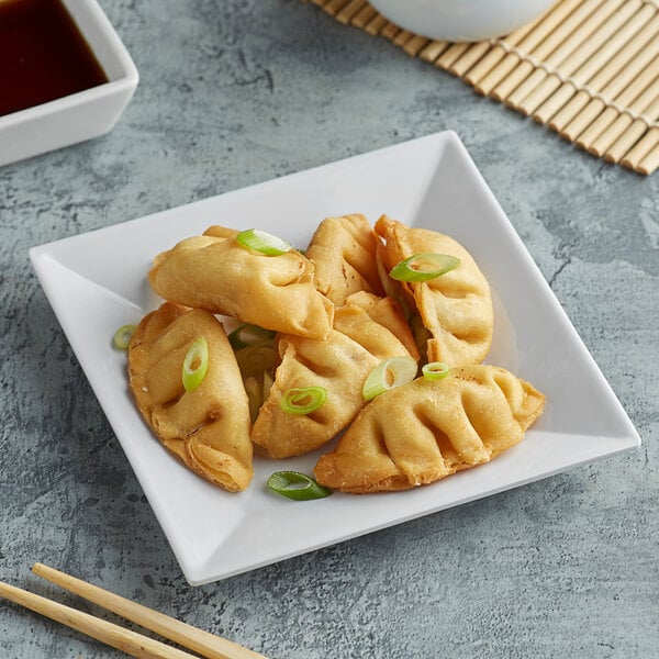 A white Acopa Rittenhouse square melamine plate with fried dumplings.