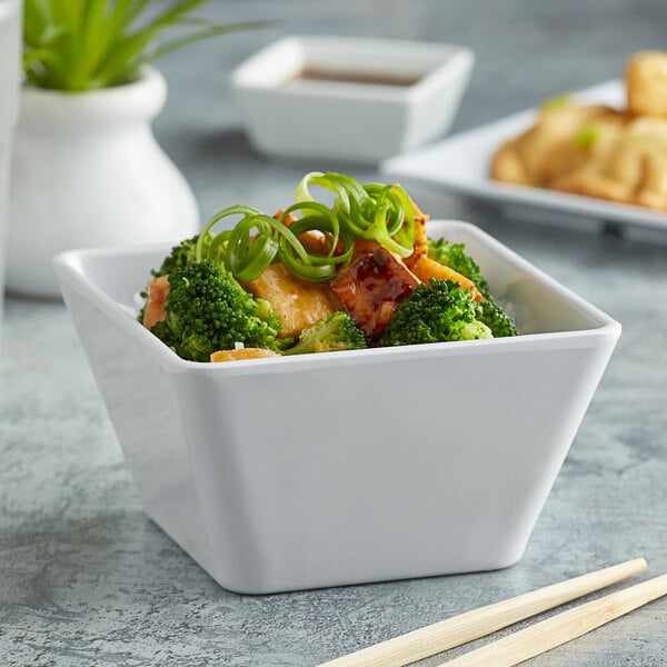 An Acopa Rittenhouse melamine bowl of food with broccoli, green onions, and chopsticks.