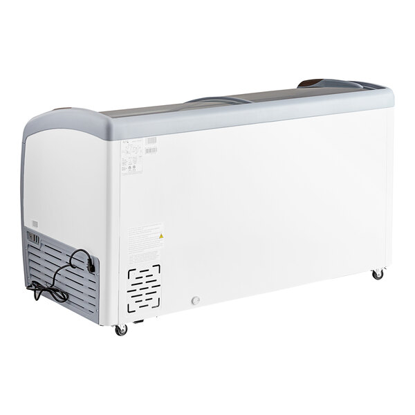 A large, white, curved top display ice cream freezer with wheels and a power cord.