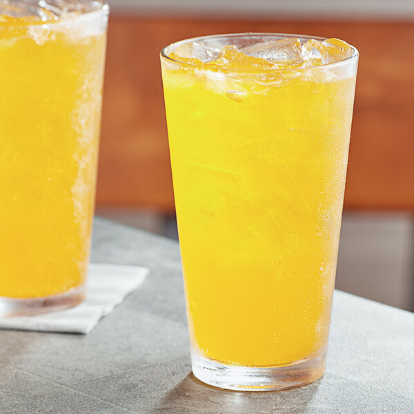 Two glasses of Boylan Bottling Co. orange liquid on a table.