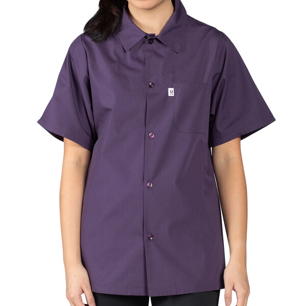 A woman wearing an Uncommon Chef eggplant purple short sleeve cook shirt.