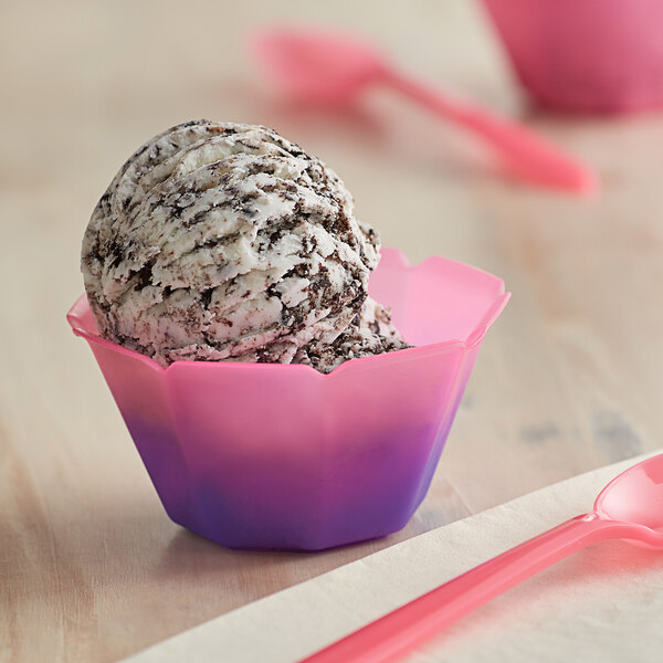 A scoop of ice cream in a pink to purple color-changing dessert cup.