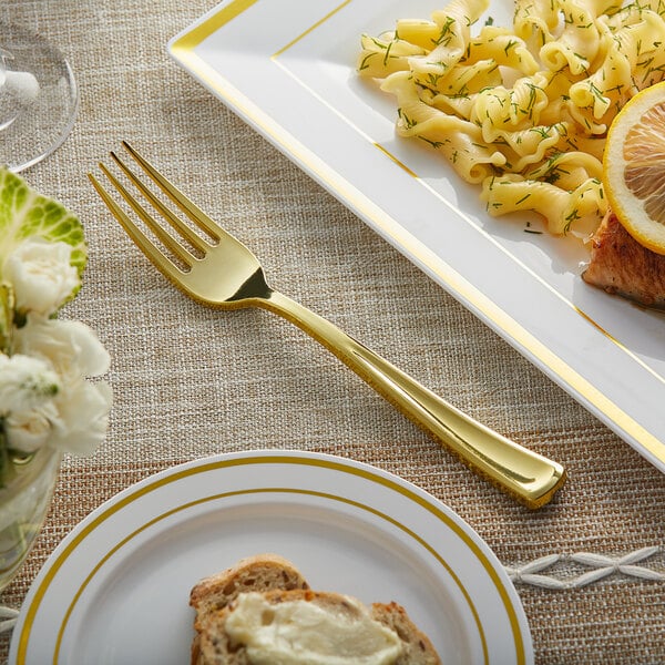 A Visions gold plastic fork on a plate of food.