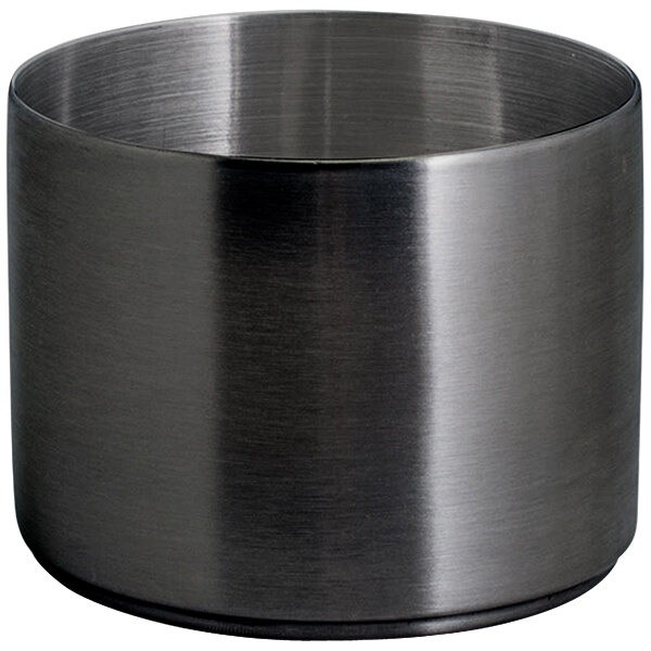 A close-up of a stainless steel ramekin with a black matte finish.