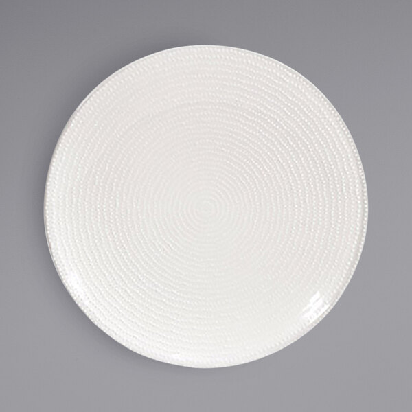 A Front of the House European white porcelain plate with an embossed spiral design.