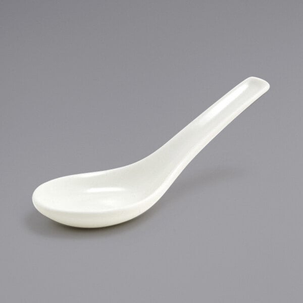 A Front of the House Catalyst European White porcelain tasting spoon with a white handle.
