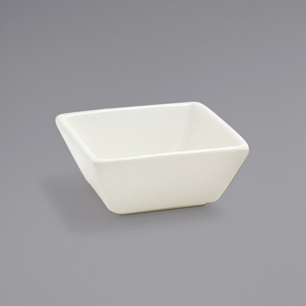 A Front of the House Catalyst Kyoto European White Tall Square Porcelain Sauce Dish on a gray background.