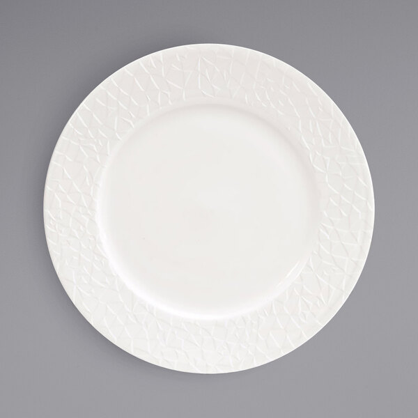 A Front of the House Catalyst European white porcelain plate with an embossed pattern.
