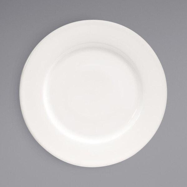 A white plate with a wide white rim on a gray background.