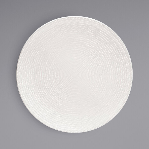 A Front of the House European white porcelain plate with a spiral pattern on the rim.