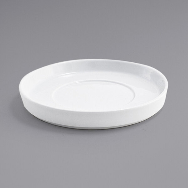 A white plate with a curved edge on a gray surface.