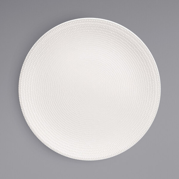 A Front of the House European white porcelain plate with a spiral pattern on the edge.