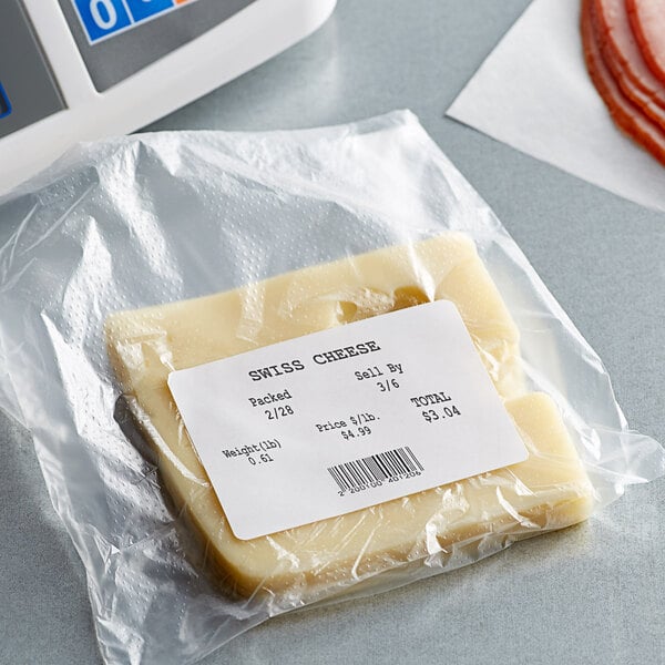 A package of Globe E13 white blank permanent direct thermal labels on a package of cheese in a plastic bag.