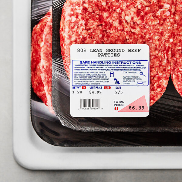 A package of ground beef patties on a tray with a white and red Globe Safe Handling label.