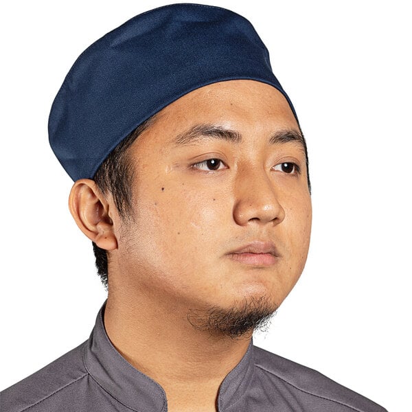 A man wearing a navy blue Uncommon Chef skull cap.