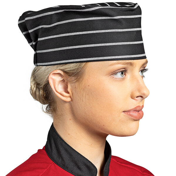 A woman wearing a Uncommon Chef chalk stripe chef's hat.