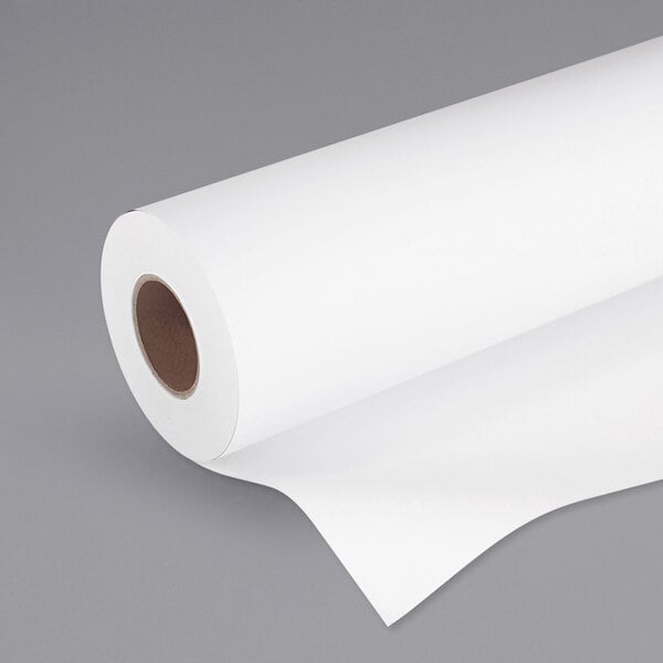 A roll of HP Inc. white large format paper on a gray surface.
