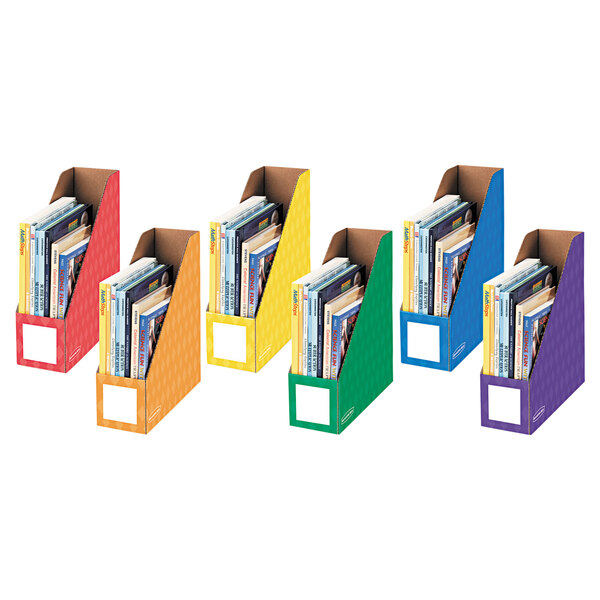 A row of Bankers Box magazine files in different colors holding books.