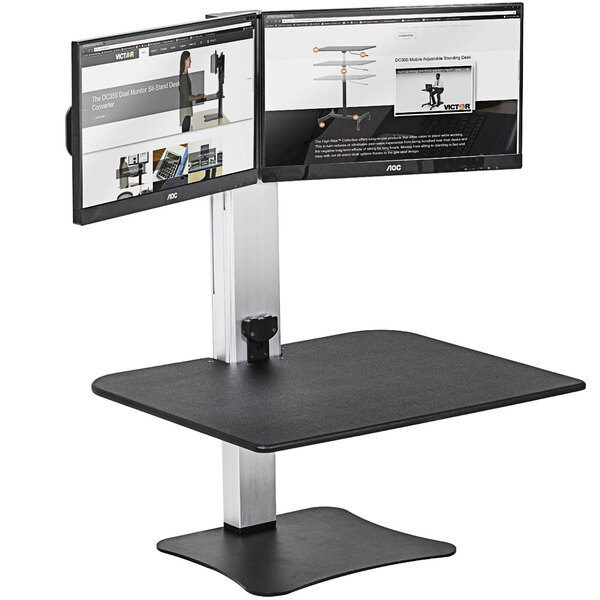 A Victor electric adjustable sit-stand workstation with dual monitors on it.