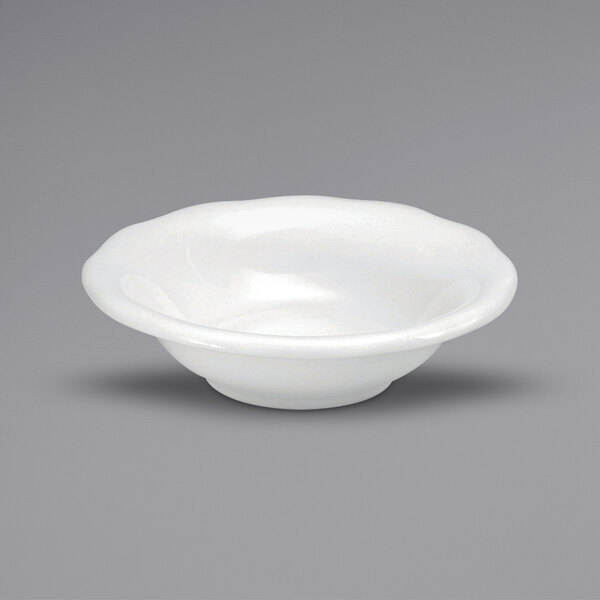 A white bowl with a scalloped edge on a white background.