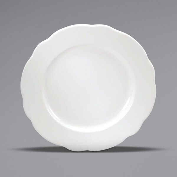 A close-up of a Oneida Buffalo Caprice cream white china plate with a scalloped edge.