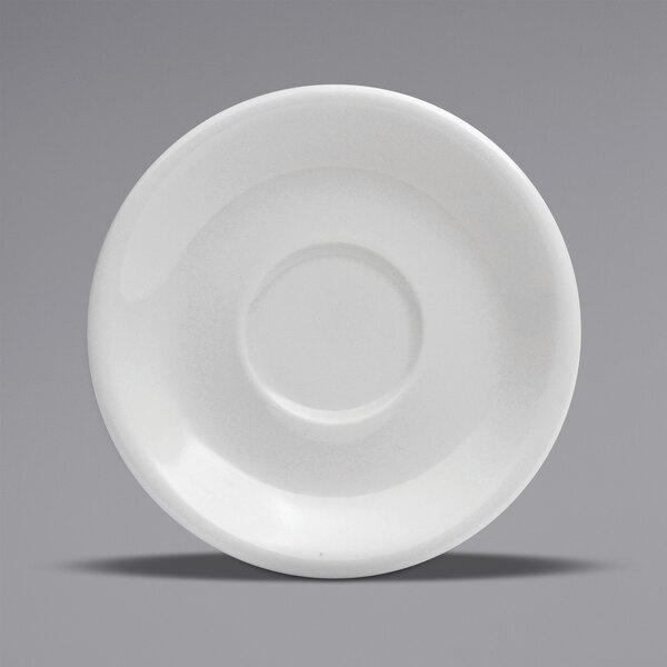 A white porcelain saucer with a circle in the middle and a rim.
