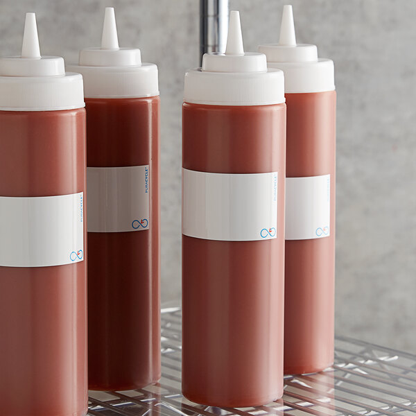 A group of sauce bottles with white Puracycle bottlewrap labels.