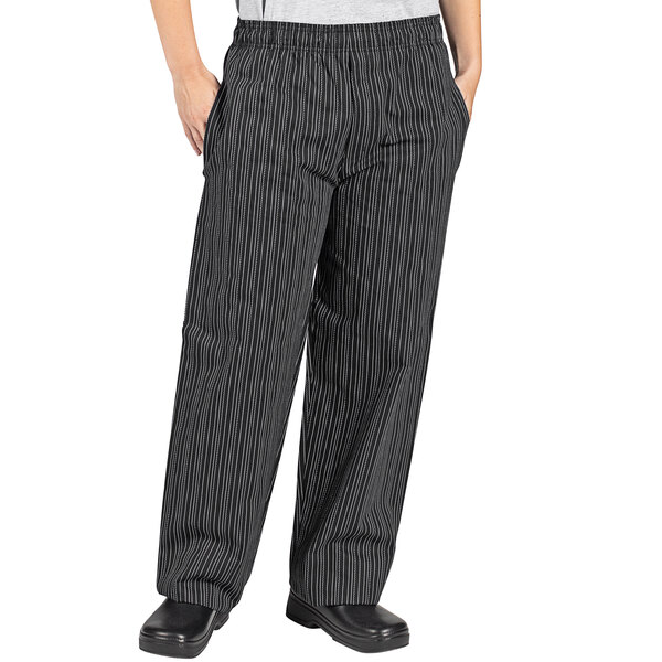 A person wearing black and white tribal stripe chef pants.