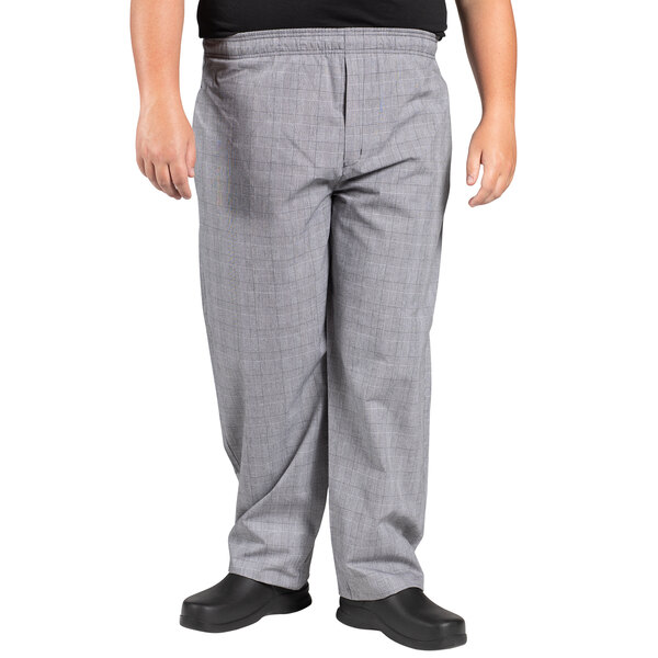 A man wearing Uncommon Chef Glen Plaid chef pants in grey.