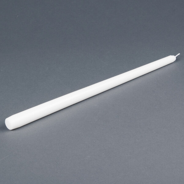 A 12 pack of white Will & Baumer taper candles on a gray surface.