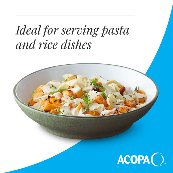A moss green matte stoneware pasta bowl filled with pasta and garnished with herbs and cheese.