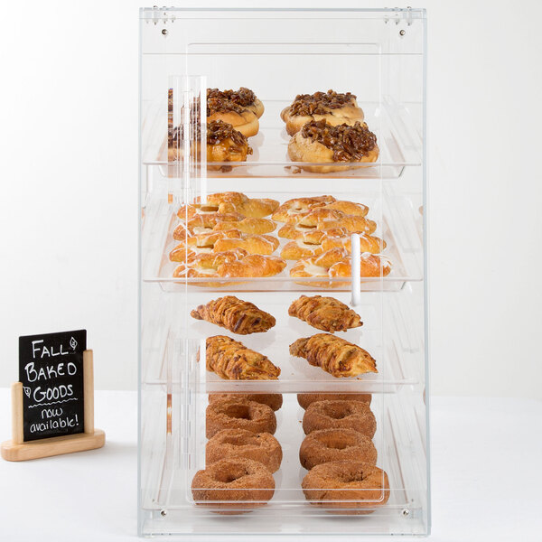 A Cal-Mil U-Build pastry display case filled with pastries and donuts.