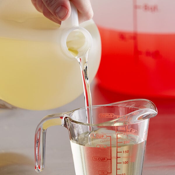 A person using Stabaleez to pour liquid into a measuring cup.