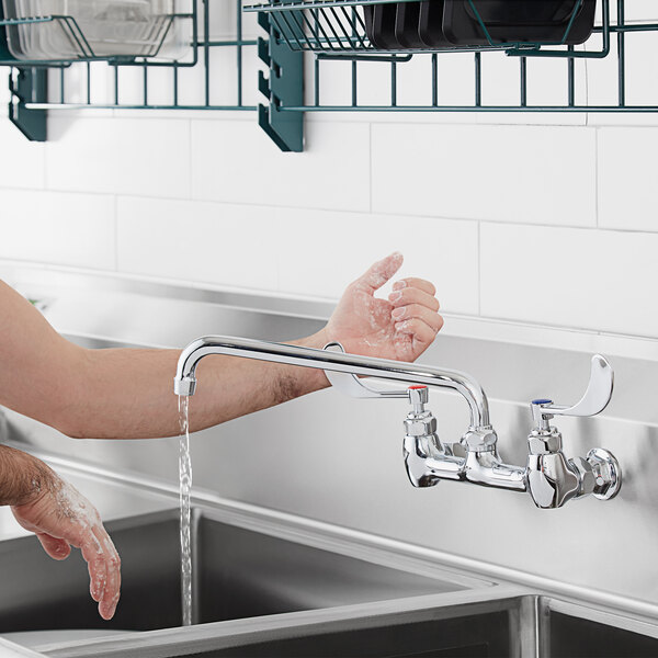 A person using a Waterloo cold water faucet handle to wash their hands in a sink.