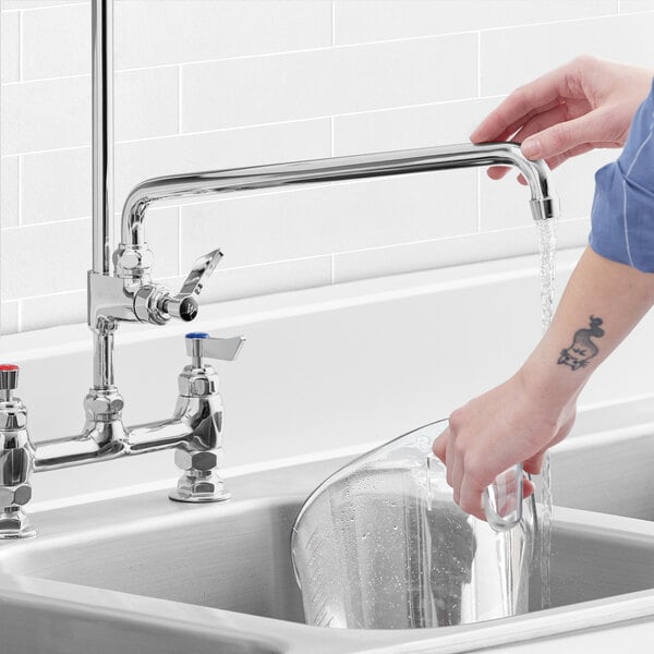 A person washing a glass using a Waterloo Add-On Faucet.