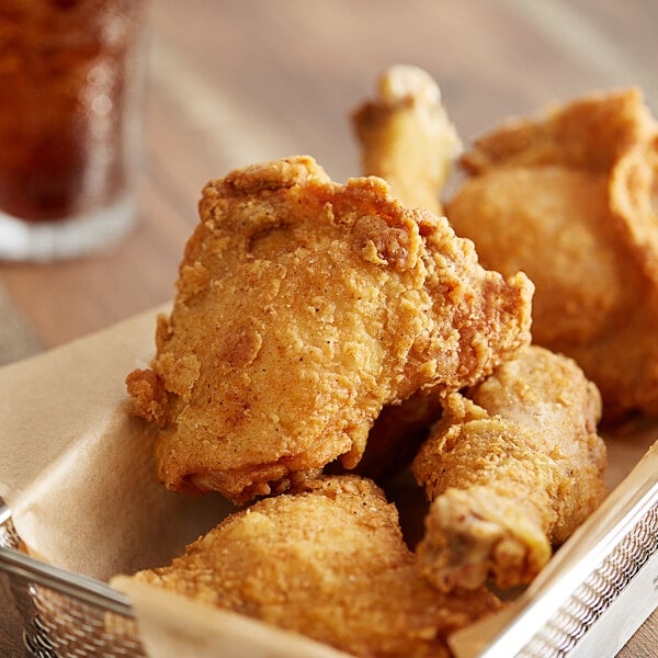 A basket of fried chicken with a brown coating.