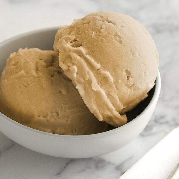A white bowl of I. Rice salty caramel ice base with a scoop of ice cream.