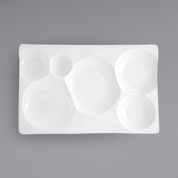 A white rectangular porcelain platter with 6 compartments, each with a circle inside.