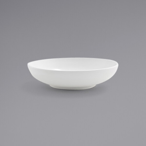 A Front of the House Harmony bright white low round porcelain bowl on a grey background.