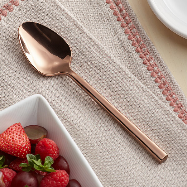 An Acopa Phoenix rose gold stainless steel teaspoon with berries on a white plate.