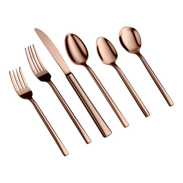 Six pieces of rose gold-colored flatware, including two forks, a knife, and three spoons, are arranged side by side on a white background.