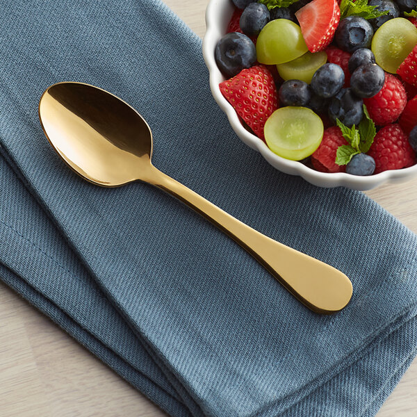 An Acopa Vernon stainless steel teaspoon in a white bowl of fruit.