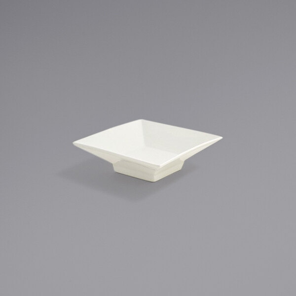 A Front of the House Catalyst Kyoto European White square sauce dish on a gray surface.