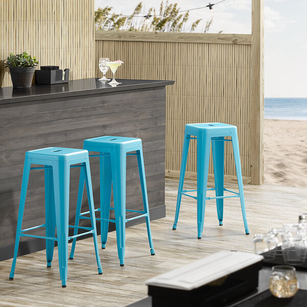Lancaster Table & Seating Alloy Series Arctic Blue Stackable Metal Indoor / Outdoor Industrial Barstool with Drain Hole Seat