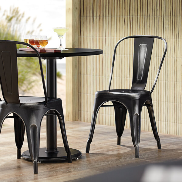 Lancaster Table & Seating Alloy Series Distressed Black Metal Indoor / Outdoor Industrial Cafe Chair with Vertical Slat Back and Drain Hole Seat