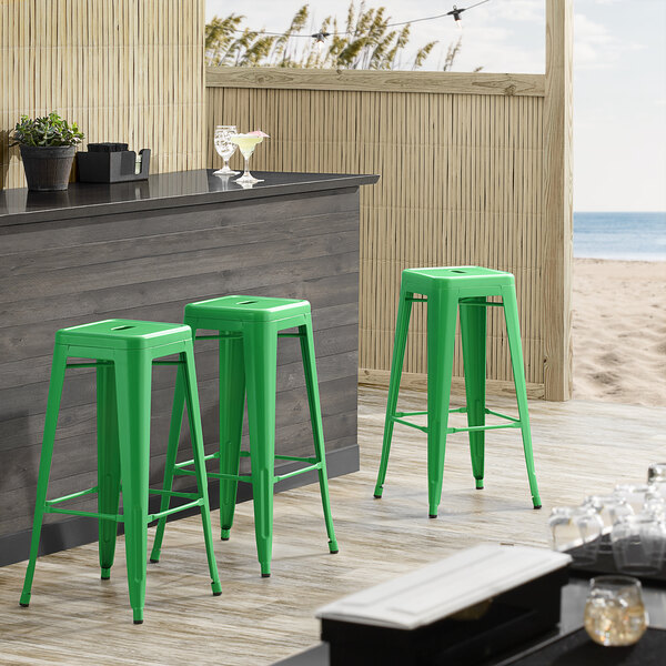 Lancaster Table & Seating Alloy Series Green Stackable Metal Indoor / Outdoor Industrial Barstool with Drain Hole Seat