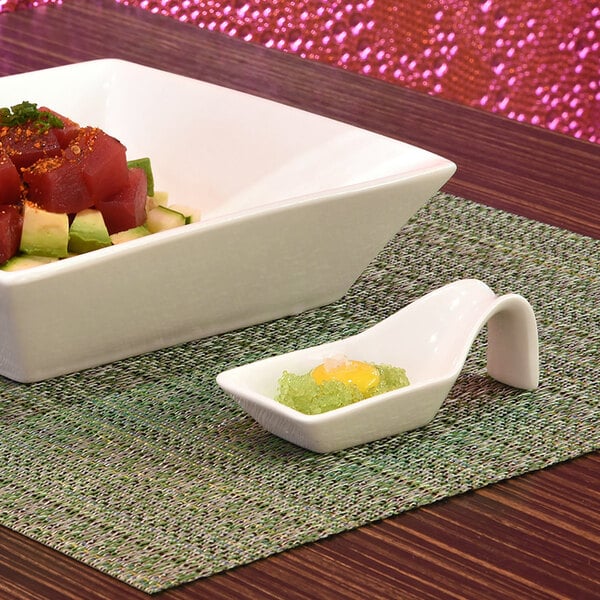 A white square bowl with raw tuna and avocado with a white porcelain Front of the House Kyoto taster spoon in it.