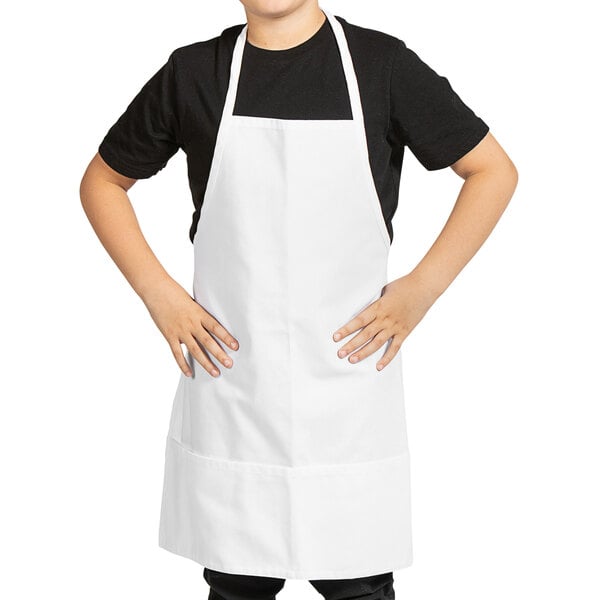 A young boy wearing a white Uncommon Chef bib apron.