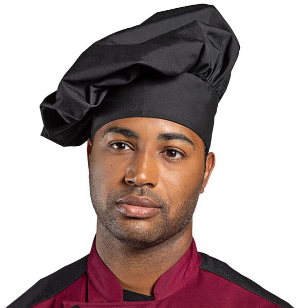 A man wearing a black Uncommon Chef poplin chef hat with black and maroon accents.
