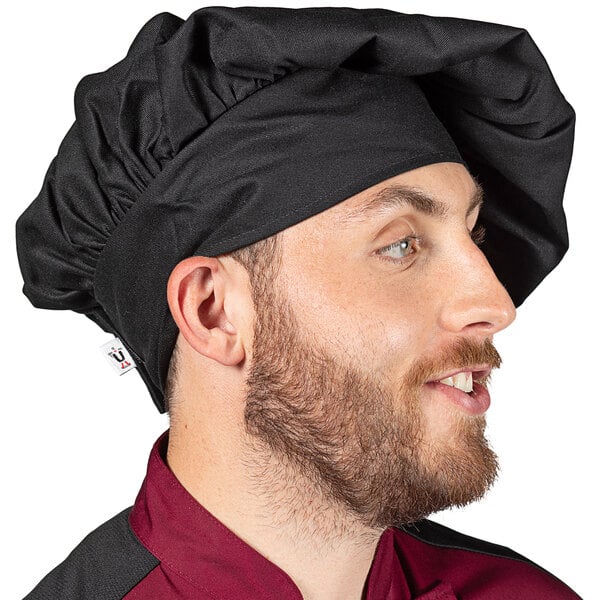 A man with a beard wearing a black Uncommon Chef Twill chef hat.